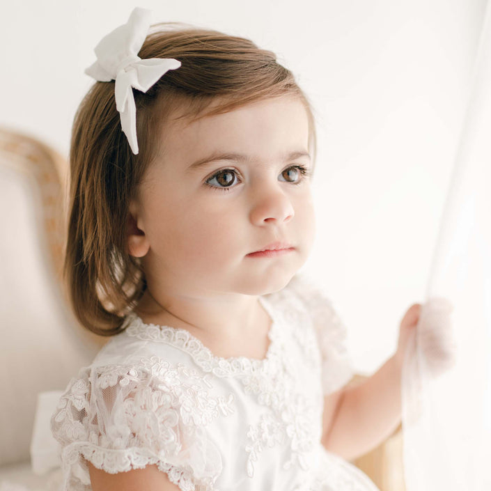 Young toddler wearing a silk bow on her head - Penelope Silk Bow.