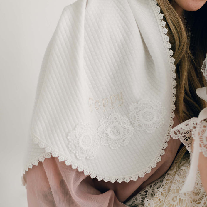 Detailed view of the Poppy Personalized Blanket featuring 'Poppy' embroidery, floral lace accents, and elegant quilted fabric.