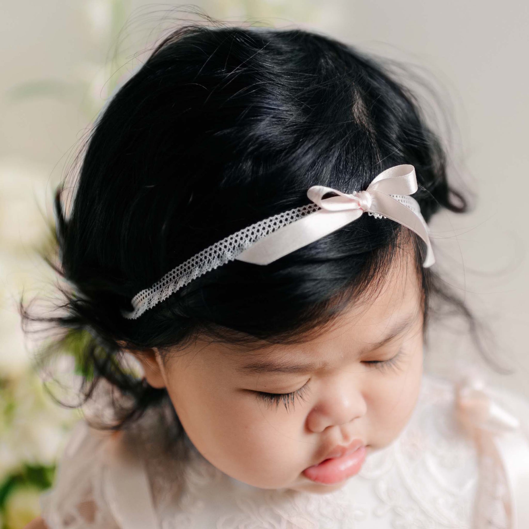 Close-up of the Sophia Silk Ribbon Headband on a baby’s head, with soft satin bow and lace trim.
