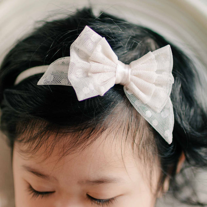Close-up of the Sophia Lace Bow Headband, highlighting the intricate lace details and soft satin finish.