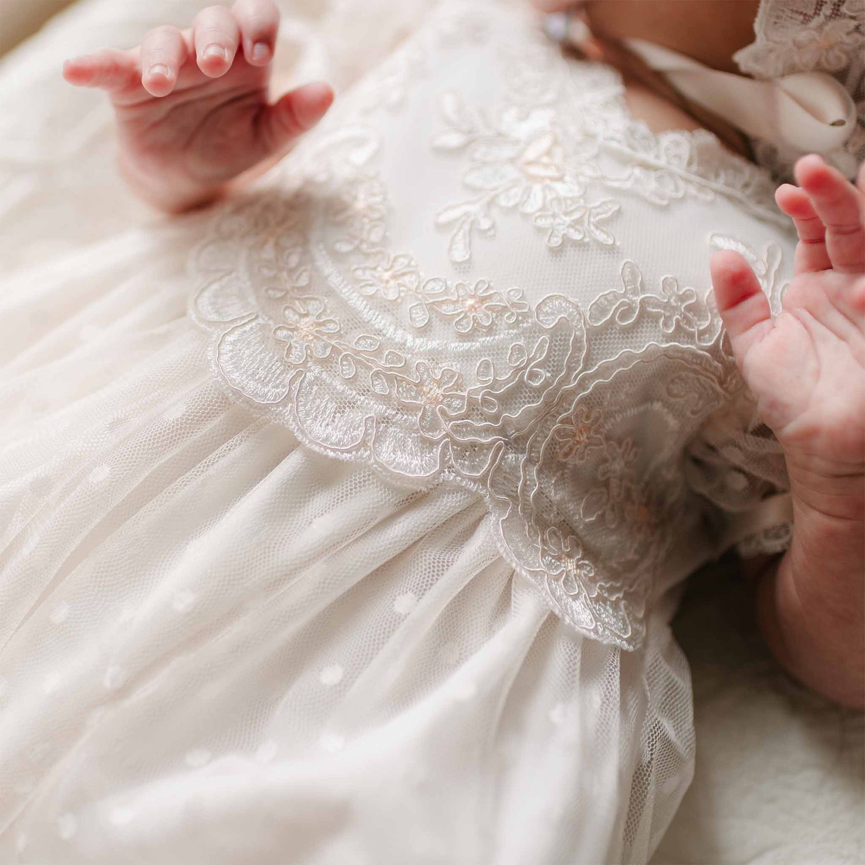 A detailed view of the Sophia Layette’s bodice, showing the intricate floral embroidery and scalloped lace trim.