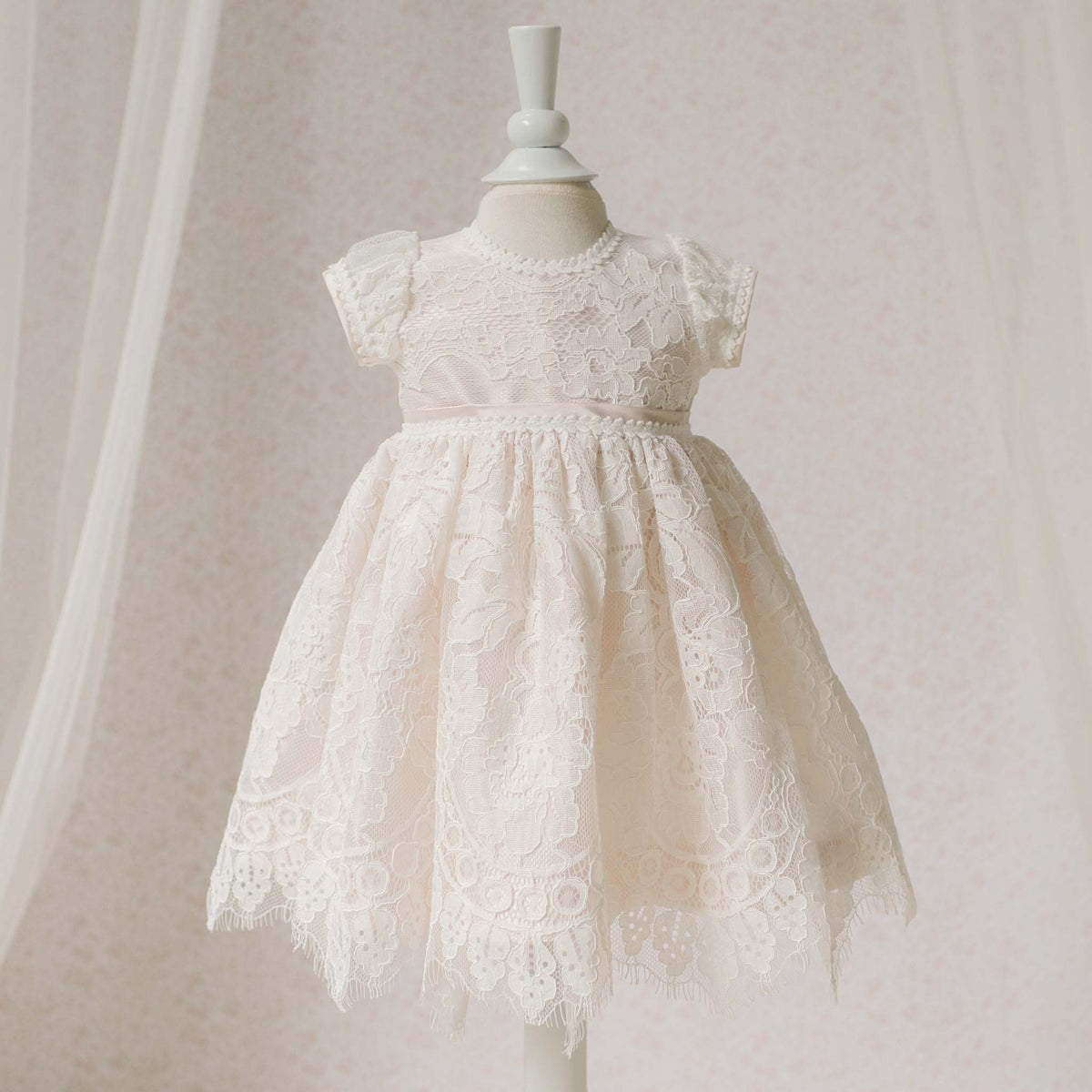 Pink and ivory dress on a mannequin against a plain background