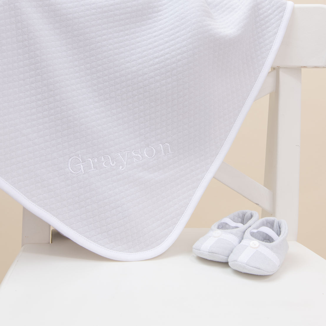 Flat lay photo of the Grayson Personalized Blanket with the Grayson Trim Booties.