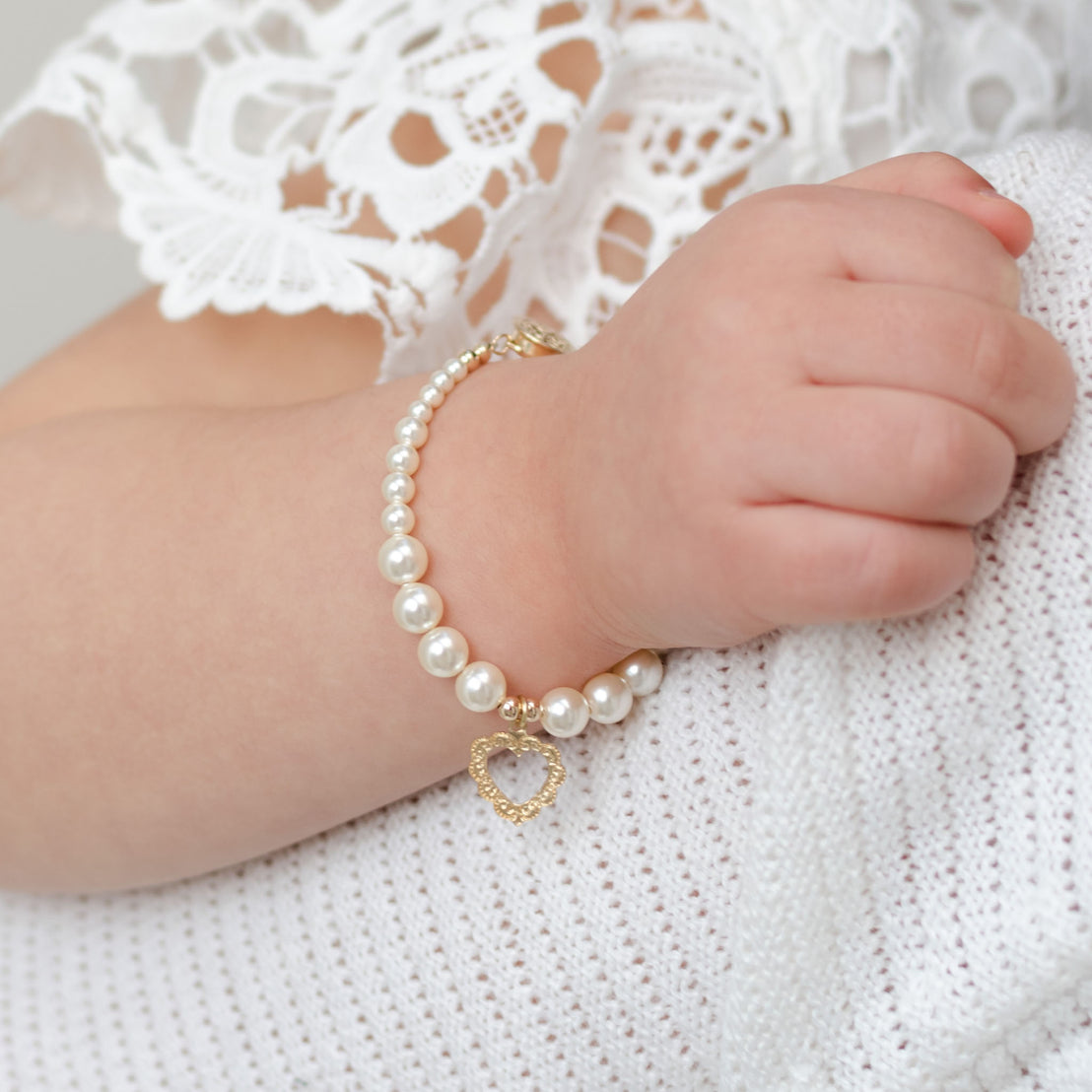 Pearl bracelet on baby with gold heart