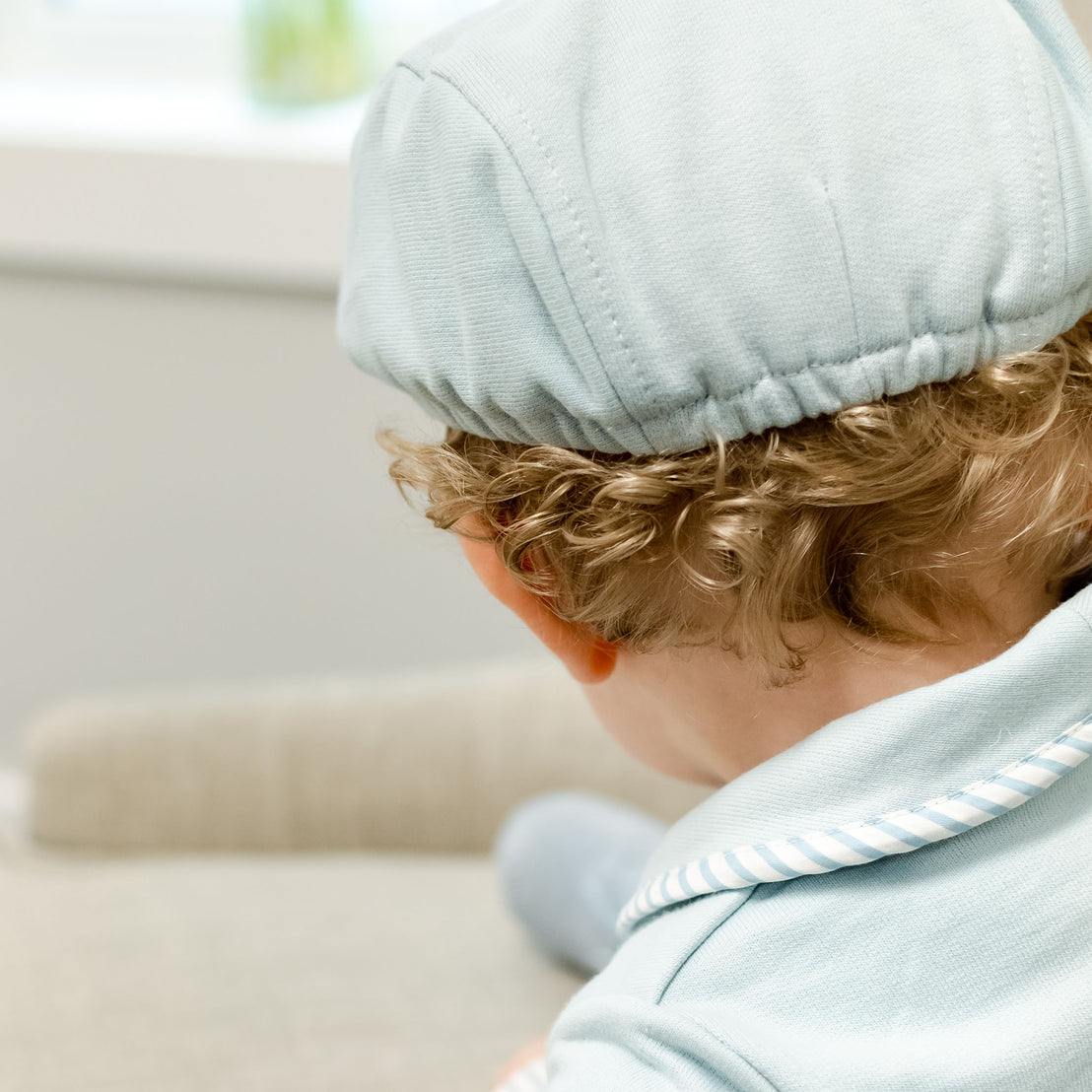 Back detail of a baby boy wearing the blue Theodore Newsboy Cap.