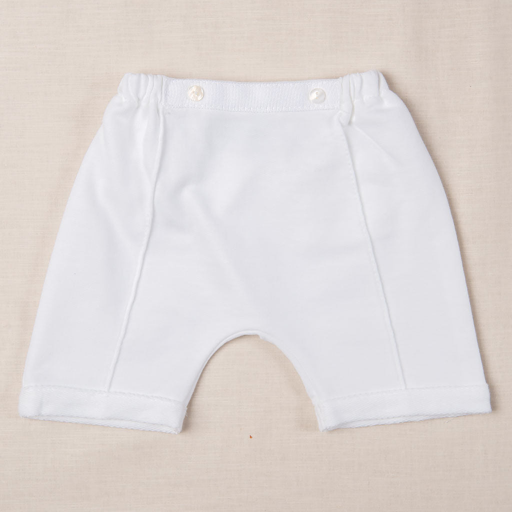 The Asher Soft Teal 3-Piece Shorts Suit is displayed on a beige surface, highlighting an elastic waistband and two buttons on the front. Made from quilted cotton, these shorts feature a simple, classic design with short legs, ideal for special occasions.