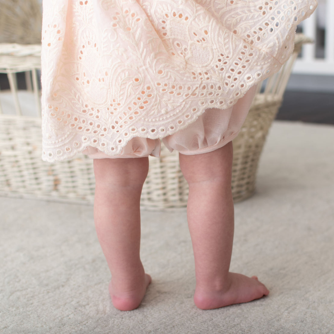 Detail of a baby wearing the pink Ingrid Romper Dress skirt and bloomers 