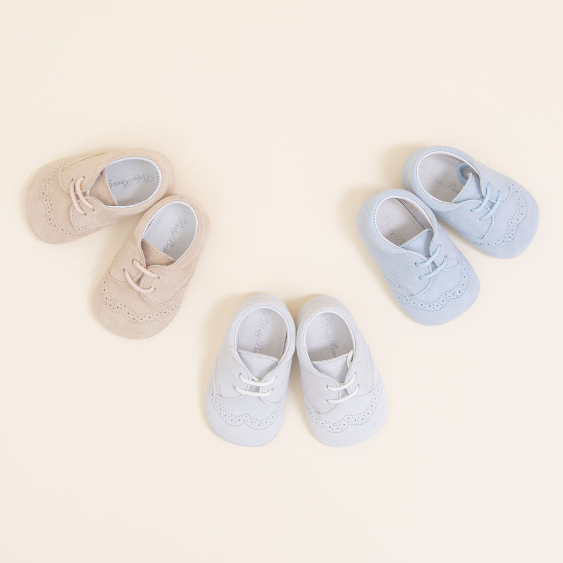 Flat lay photo of three pairs of Theodore Suede Shoes. Made from 100% suede with detailed edging. Available in colors blue, grey, and tan.