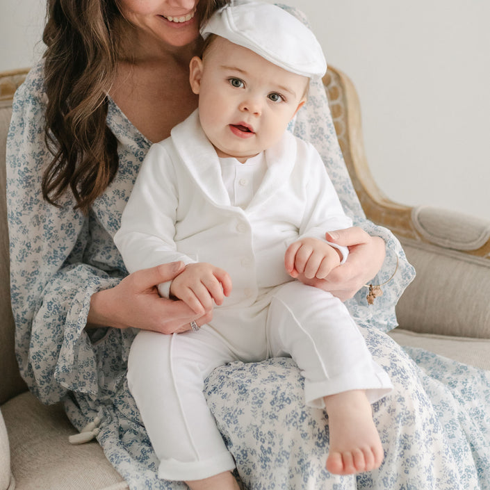 Baby boy sitting on his mother's lap. He is wearing the Miles 3-Piece Suit, including the jacket, pants, and onesie
