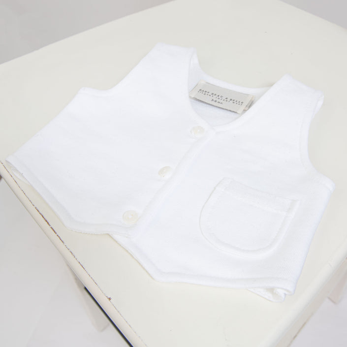 Flat lay photo of the Elliott Vest, made with a white French Terry Cotton with a three button closure and darling pocket detail.