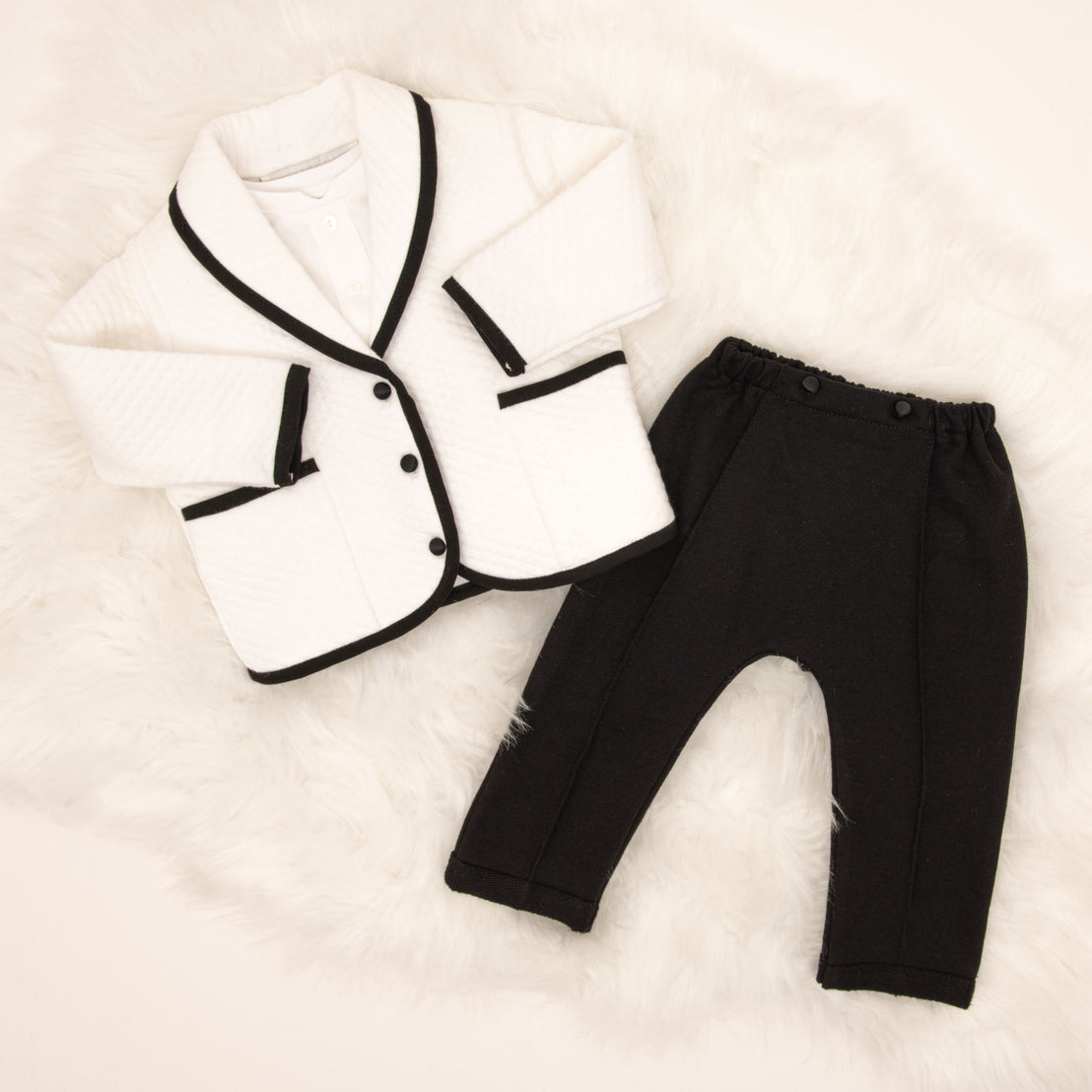 Flat lay of the white James 3-Piece Suit, including the Jacket, Pants and Onesie.