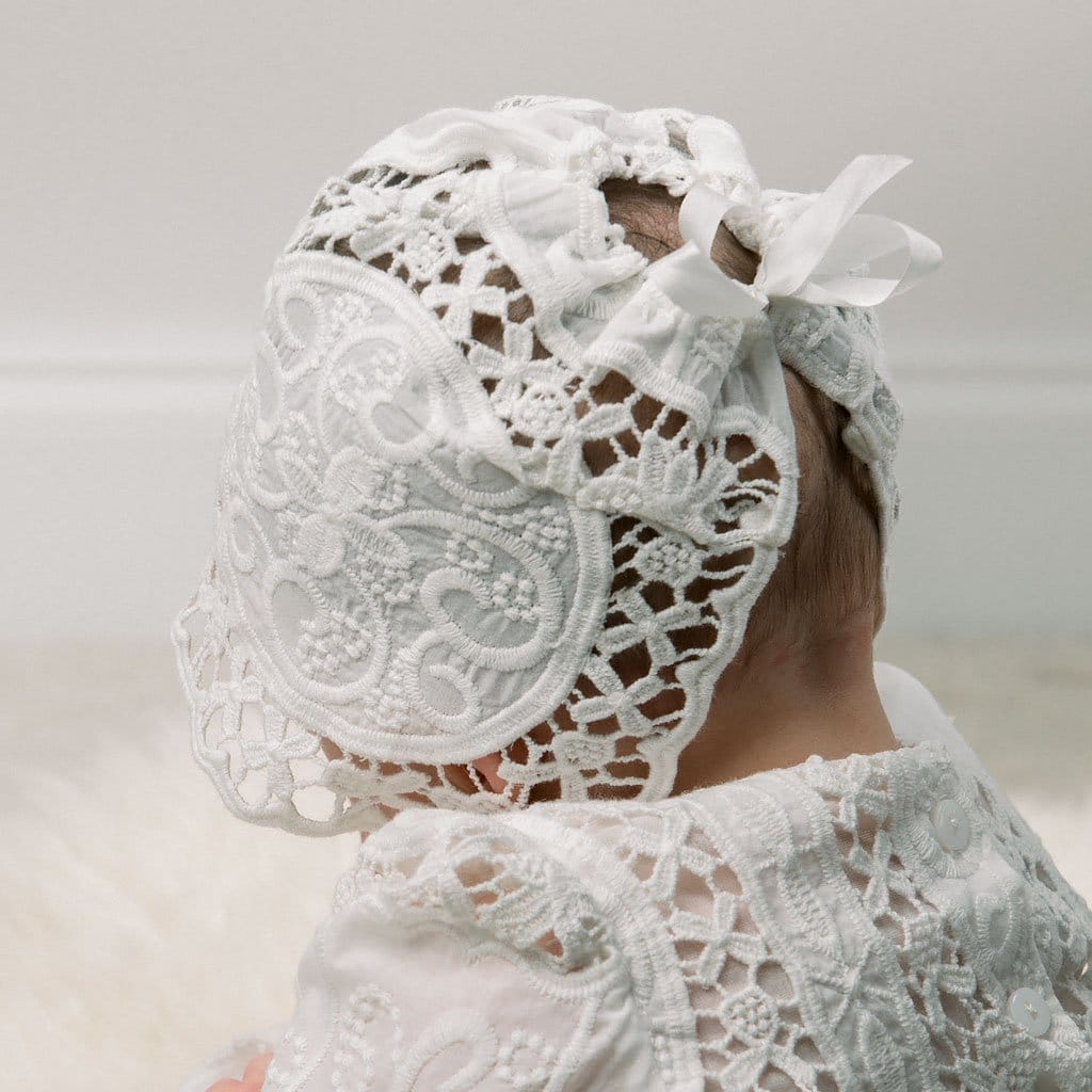 Close-up backside view of the Adeline Lace Christening Bonnet as worn by a baby girl. This angle showcases the cinched silk ribbon tie, ensuring a snug fit for the bonnet.