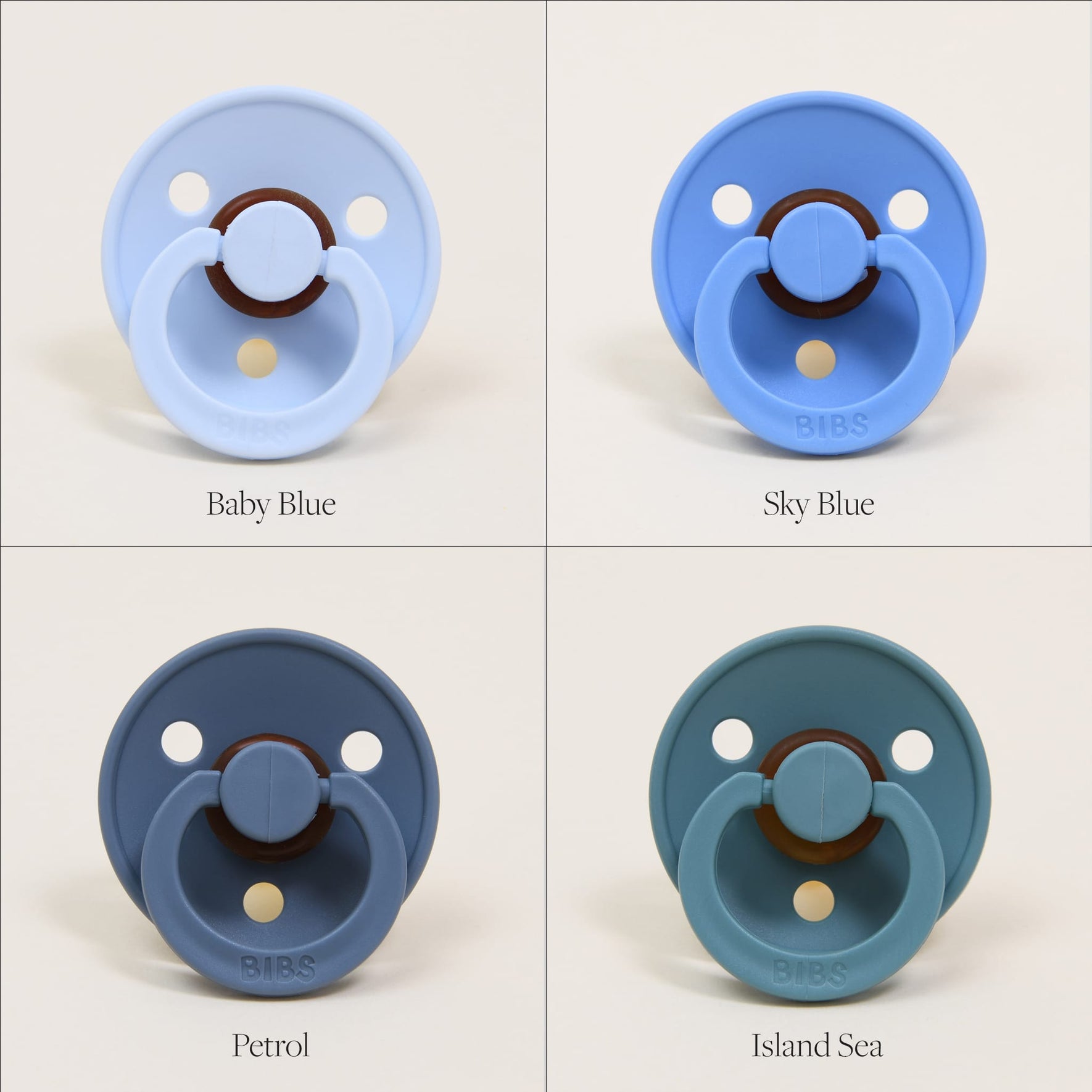 The image showcases four Bibs Pacifiers crafted from natural rubber, set against a beige background. In the top left corner is Baby Blue, top right is Sky Blue, bottom left is Petrol, and bottom right is Island Sea. Each Danish-crafted pacifier features a circular shield and ring handle in calming shades of blue, ideal for self-soothing.