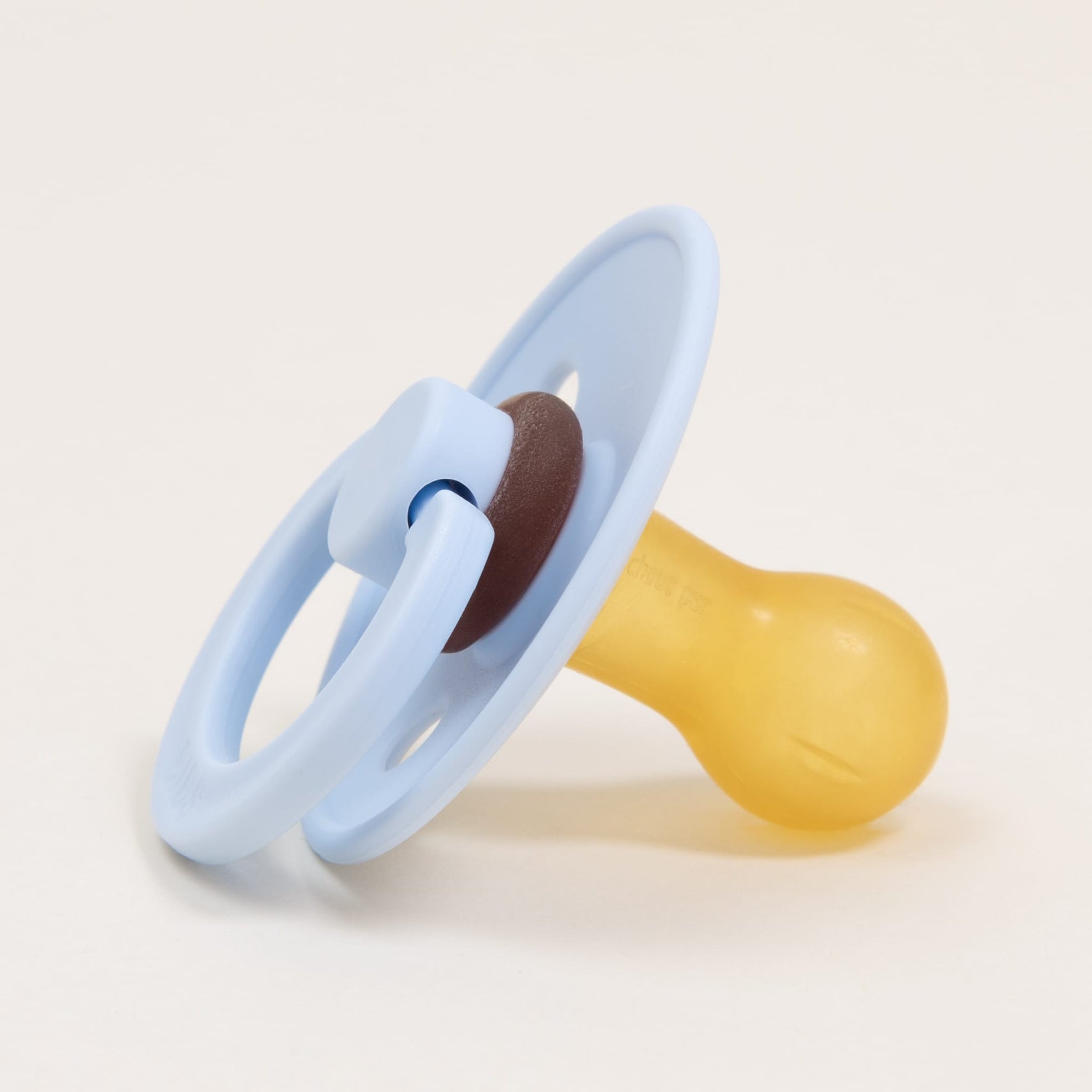 A Bibs Pacifier 2 Pack from Denmark, designed with a baby blue plastic shield and holder, featuring a brown and yellow natural rubber nipple, set against a plain white background. Ideal for helping little ones self-soothe.