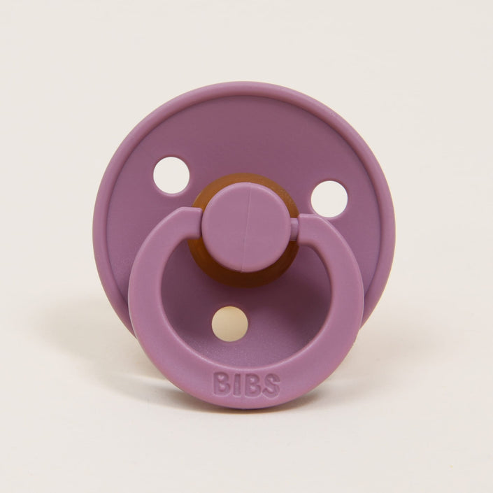 This classic and sophisticated heather-colored infant pacifier from the Bibs Pacifier 2 Pack is made from natural rubber and features a round shield with three ventilation holes. The looped handle is embossed with the BIBS brand name, making it ideal for babies to self-soothe, set against a plain white background.