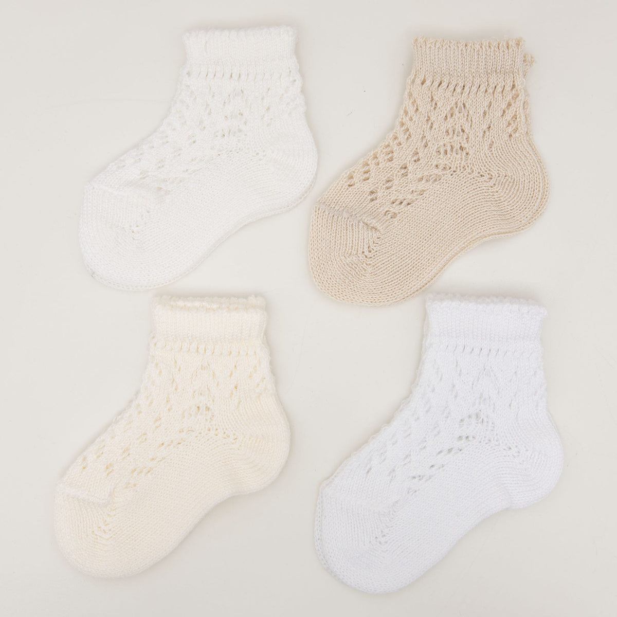 Arranged in a neat two-by-two grid on a light background, four Crochet Socks highlight their charming design. Available in two colors—white and beige—each sock boasts an intricately crocheted, textured pattern that showcases delicate craftsmanship.