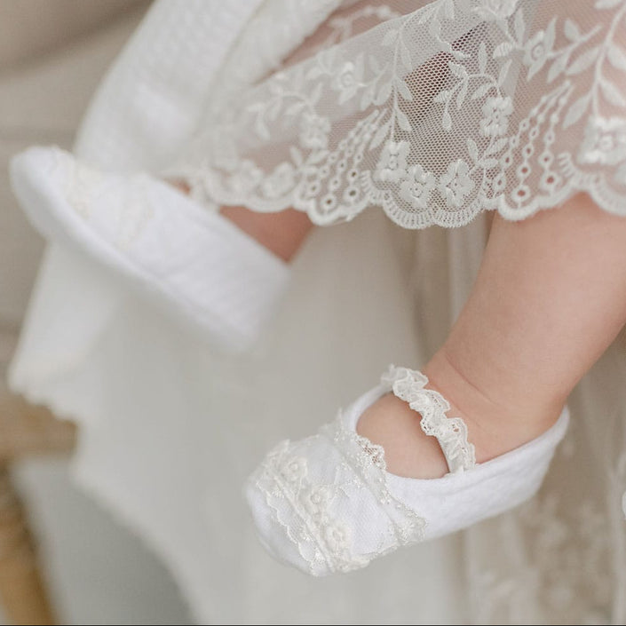 Closeup of a baby girl wearing Ella baptism, featuring the delicate details of the cotton and lace.