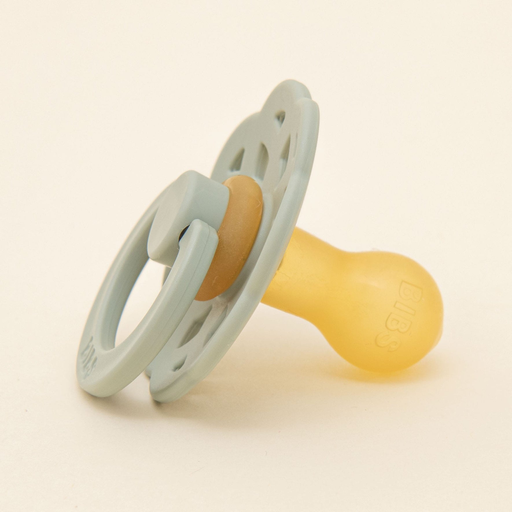 A close-up flat lay photo of the ivory pacifier from the Ella Pacifier Set.