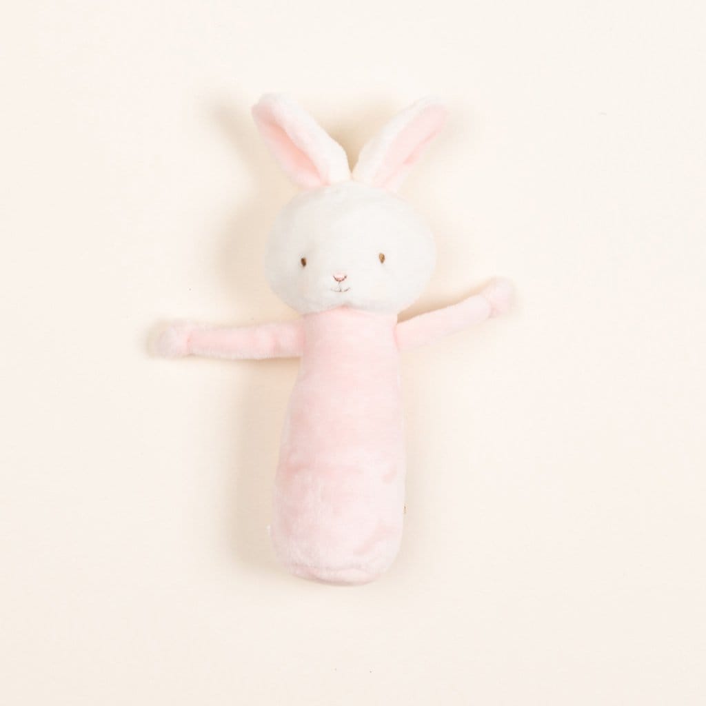 The Friendly Chime Rattle is a soft, plush toy designed as a pink and white rabbit with floppy ears, featuring baby-safe velour chime rattle and soft embroidered details, with outstretched arms set against a plain white background.