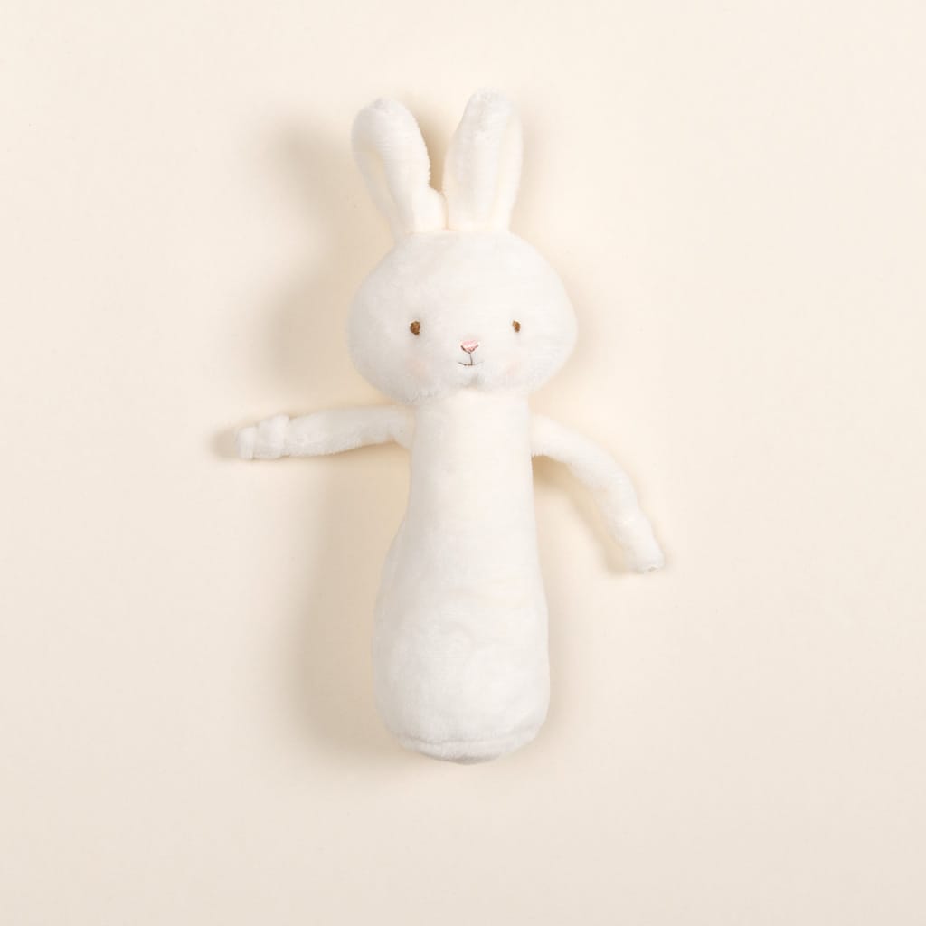 Introducing the Friendly Chime Rattle, a gentle velour plush toy designed as a rabbit with soft white fur, long ears, and intricate embroidered facial features. This baby-safe chime rattle rests on a light beige background, perfect for delighting little ones.