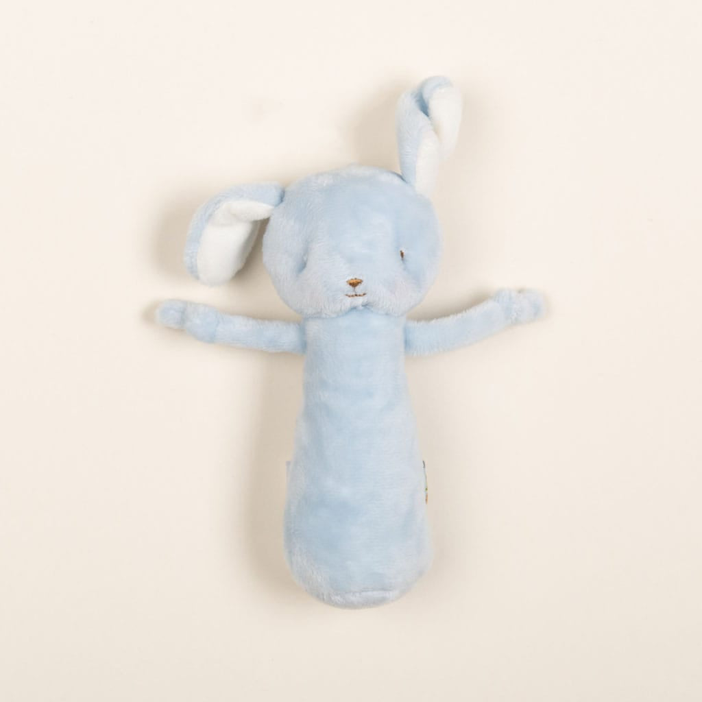 The Friendly Chime Rattle is a gentle, plush toy shaped like a bunny with long ears and small arms. It features soft embroidered details and is designed to be baby-safe. Styled on a plain, light background, this velour chime rattle comes in a soothing blue color.