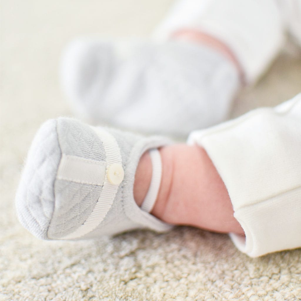 Grayson trim booties pictured on a baby boy.