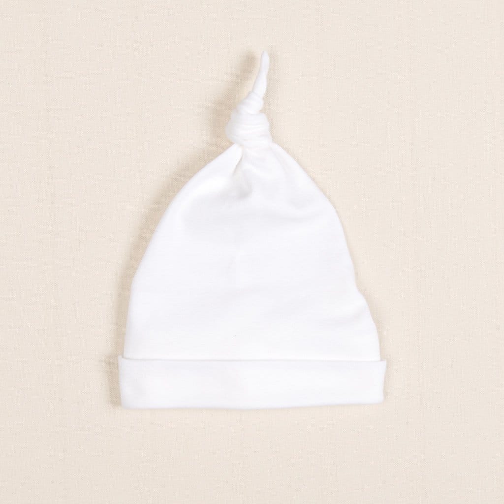 Flat lay photo of the Harrison Knot Cap made with premium soft pima cotton in white with a knot design on top