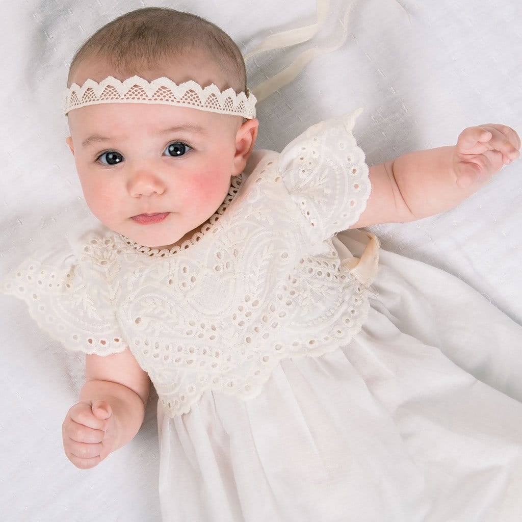 Baby wearing the Ingrid Lace Headband and ivory Ingrid Romper Dress.
