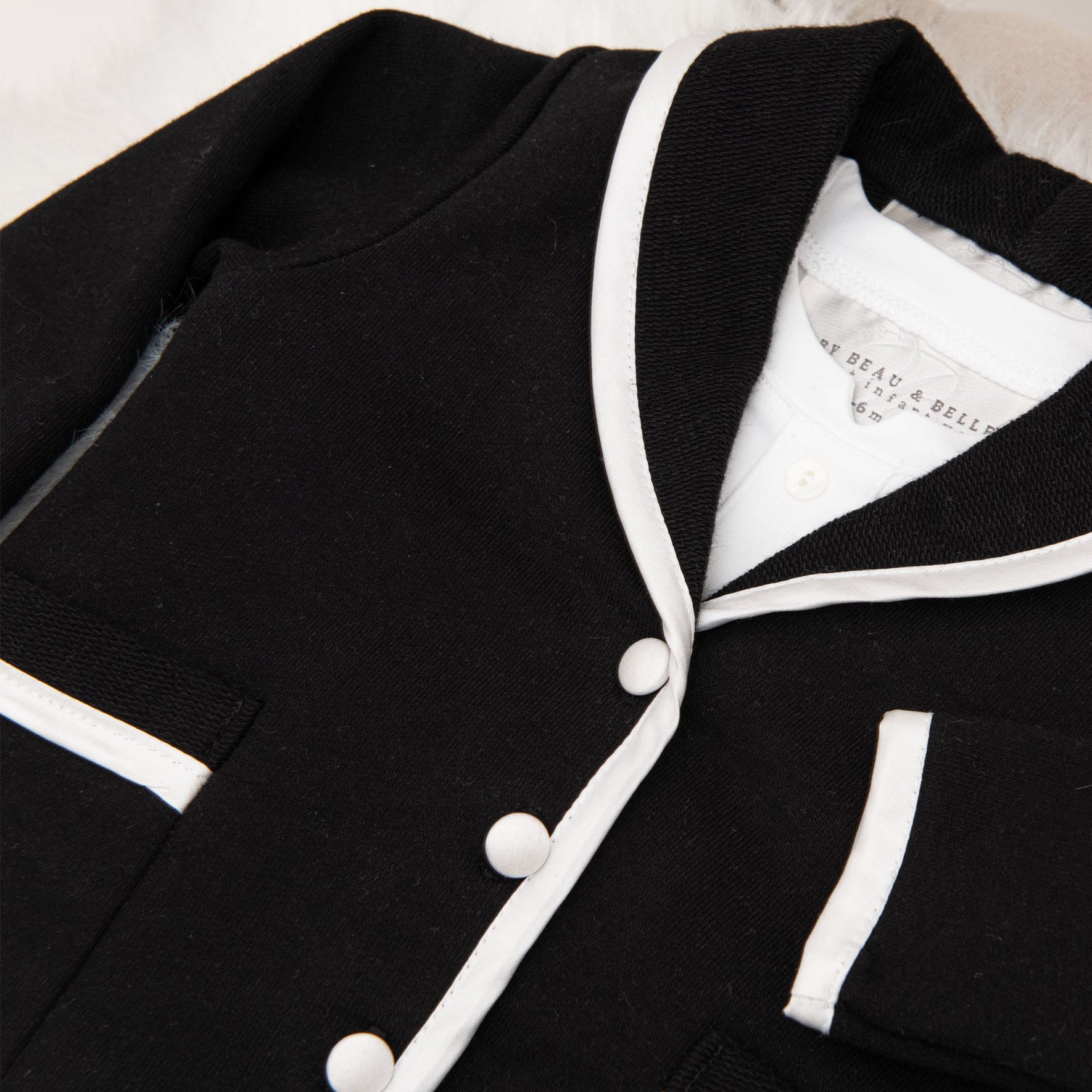 A close-up of the James 3-Piece Suit in black, focusing on the jacket’s fine details, including the white-trimmed lapels and buttons.