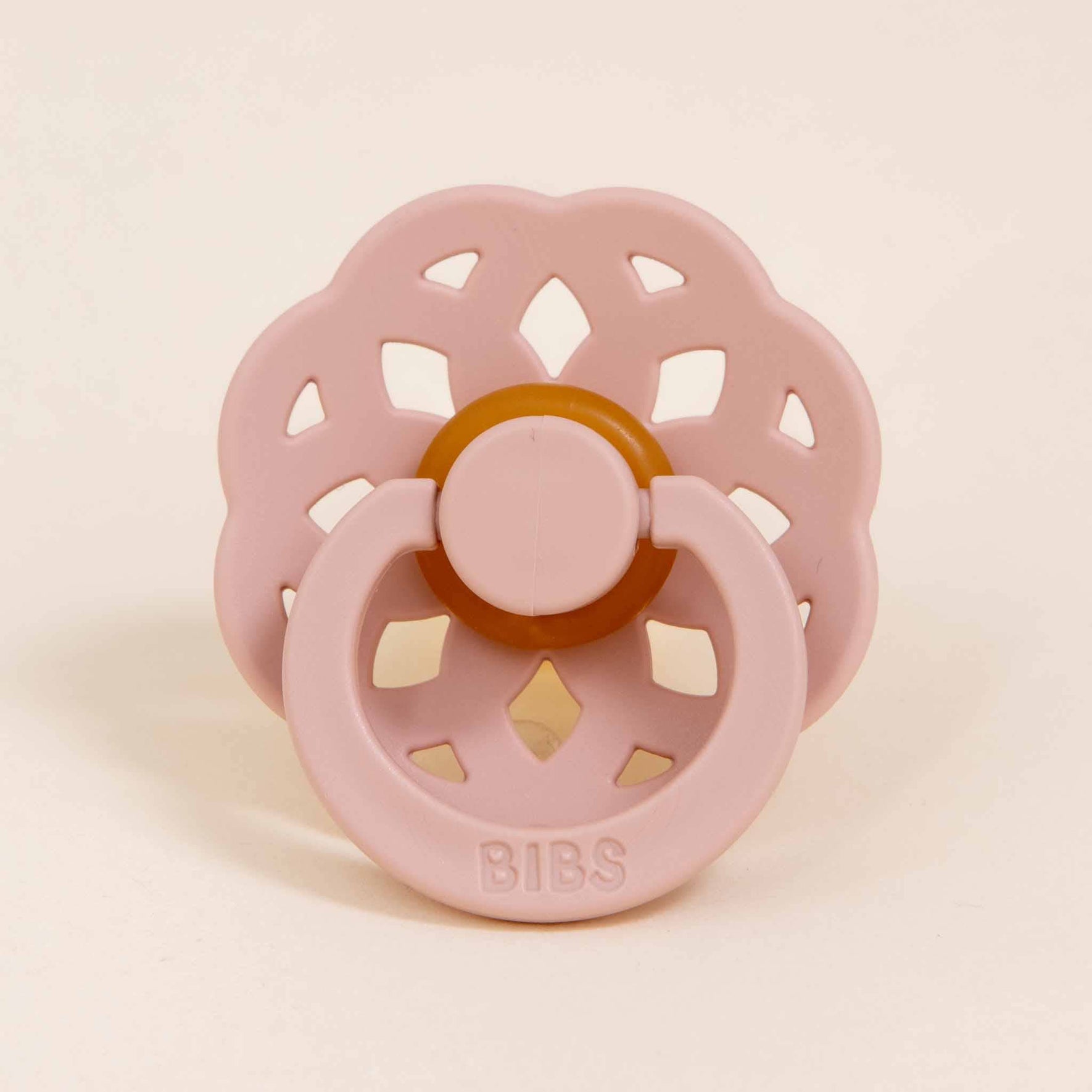Close-up of the blush pacifier from the Lola Pacifier Set, featuring a petal-inspired design with a silicone base.