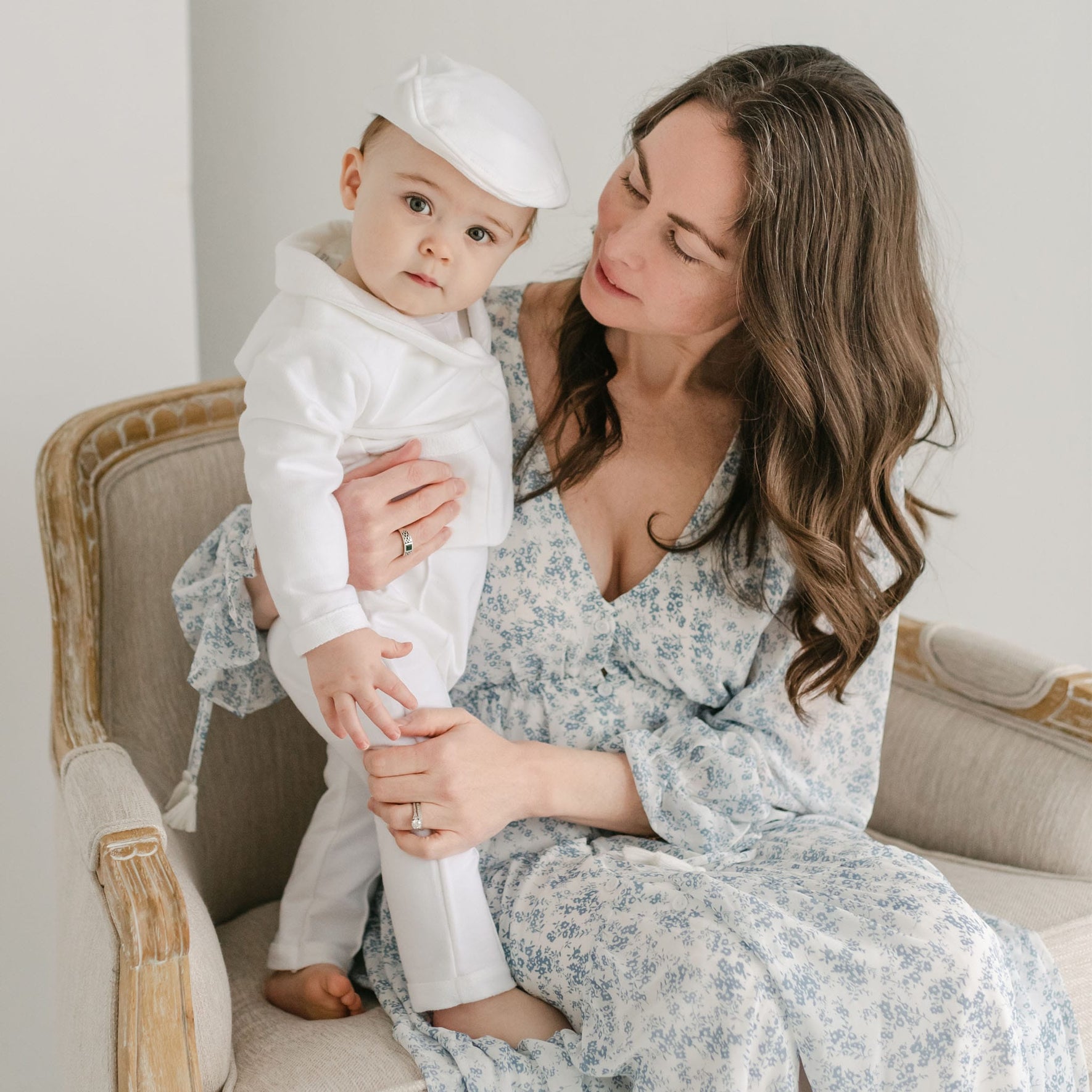 Photo of a baby boy being held by his mother. He is wearing the Miles 3-Piece Suit