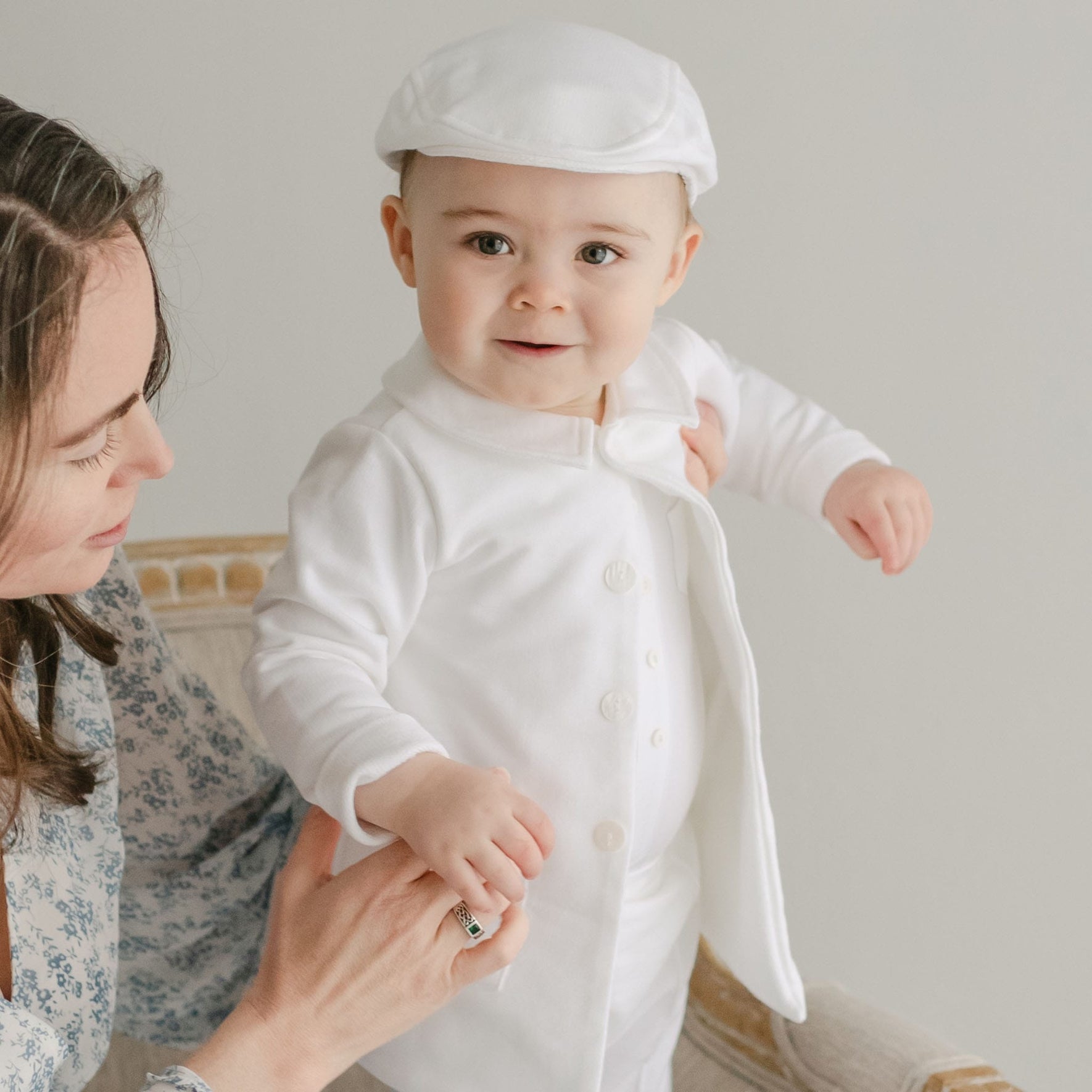 Smiling baby boy wearing the Miles Trench Coat made from white french terry cotton