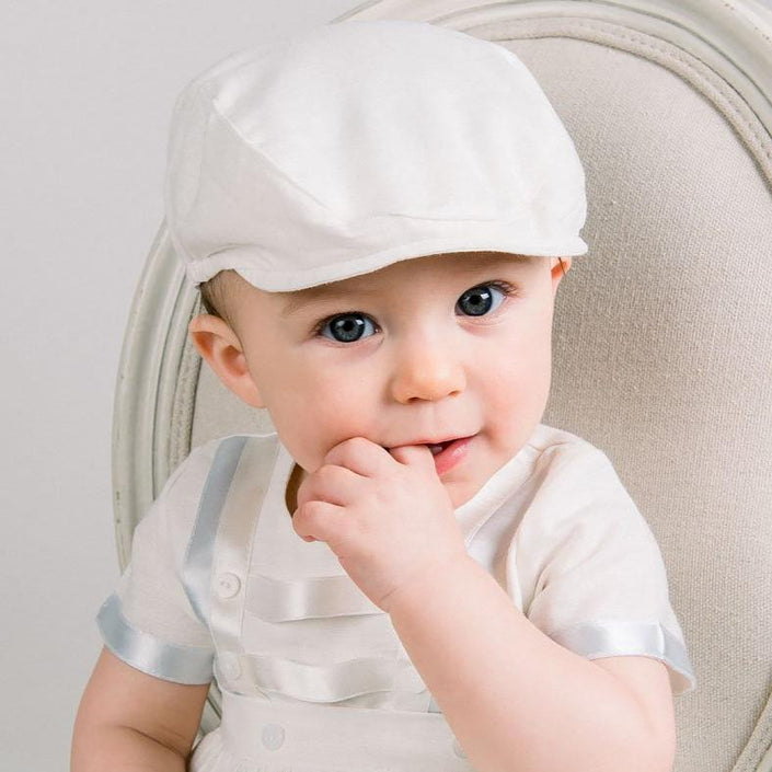 Baby boy sitting in a chair and wearing the Owen Linen Newsboy and matching Romper